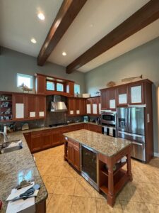 Cherry-stained kitchen cabinets before refinishing in a Jacksonville Beach, FL home